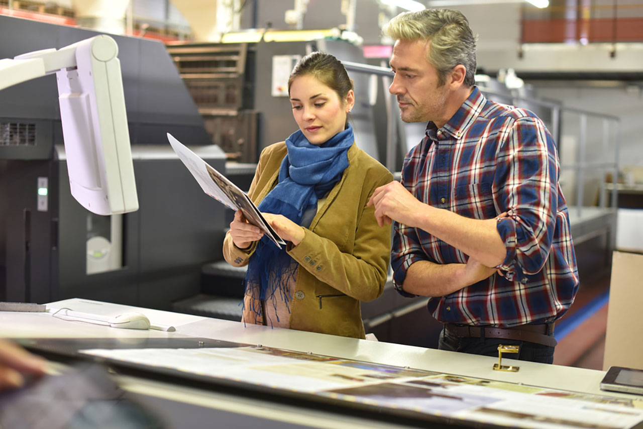Man in printing house showing client printed documents