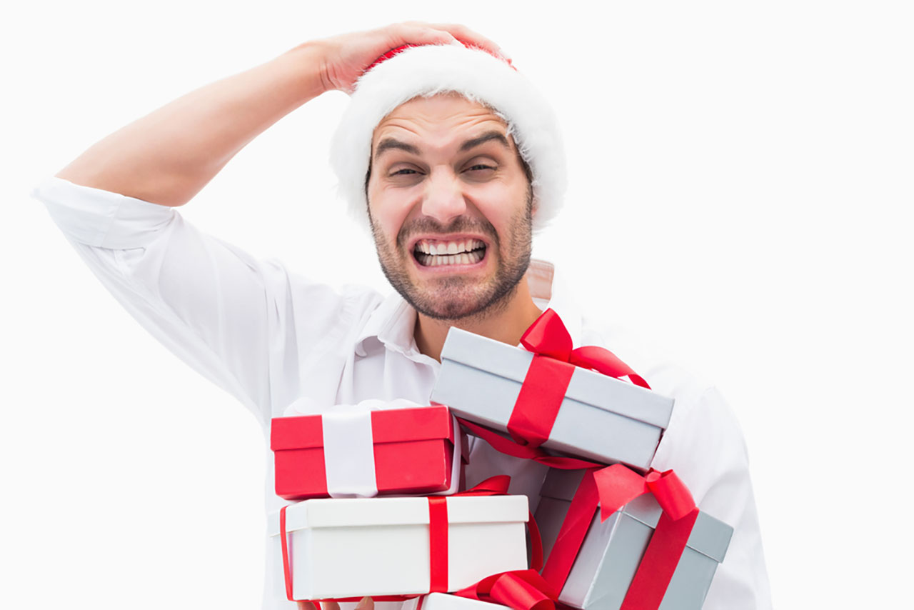 Man in Santa Hat is Stressed Holding Too Many Presents 